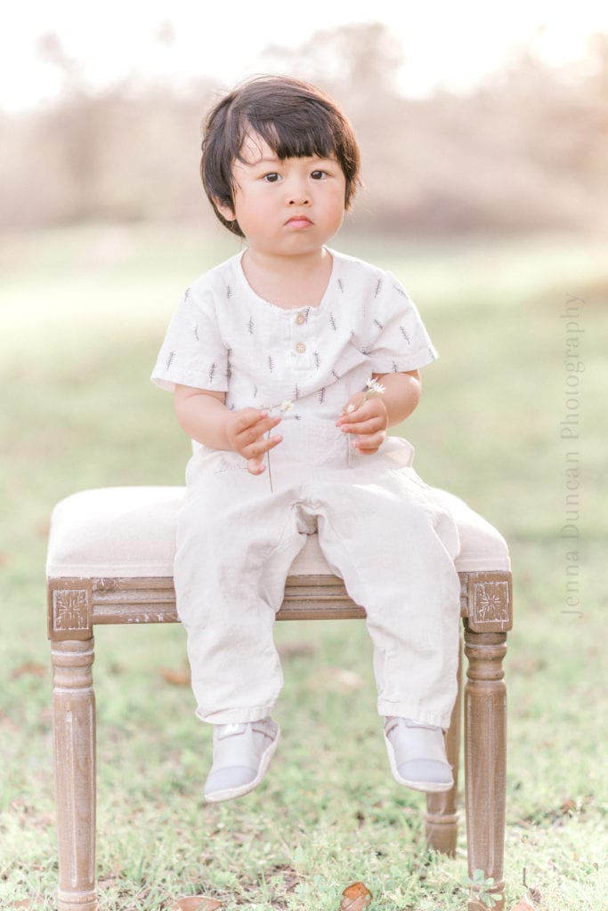 Toddler two year old boy sitting in a field for milestone birthday photo session