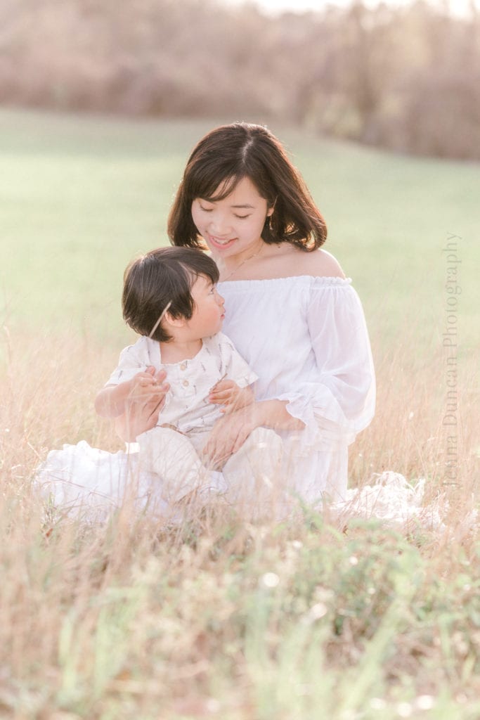 Mom and toddler sitting in a field of flowers for a family photography session in Houston